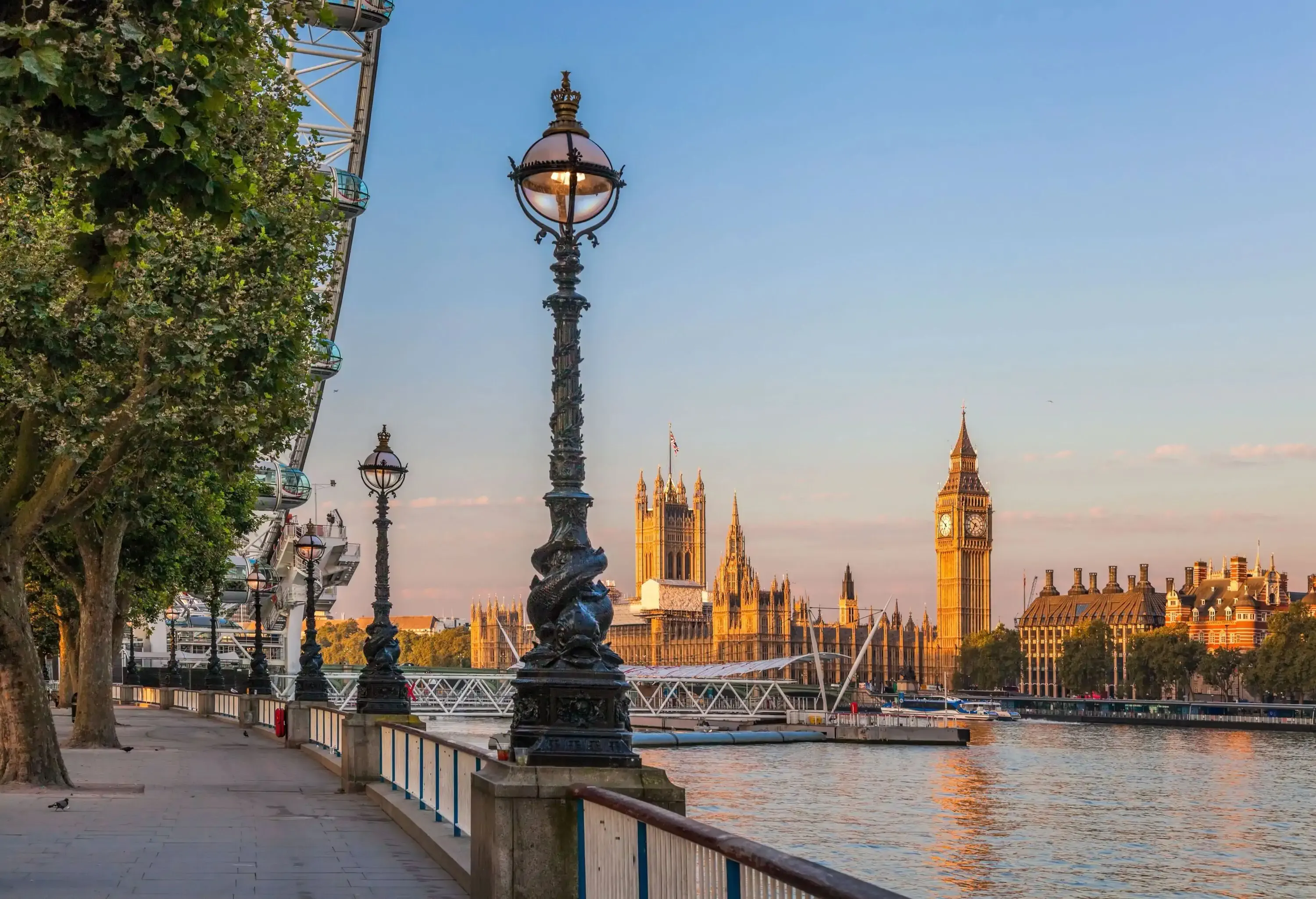 A riverside promenade with the Westminster Hall and Big Ben in the background.
