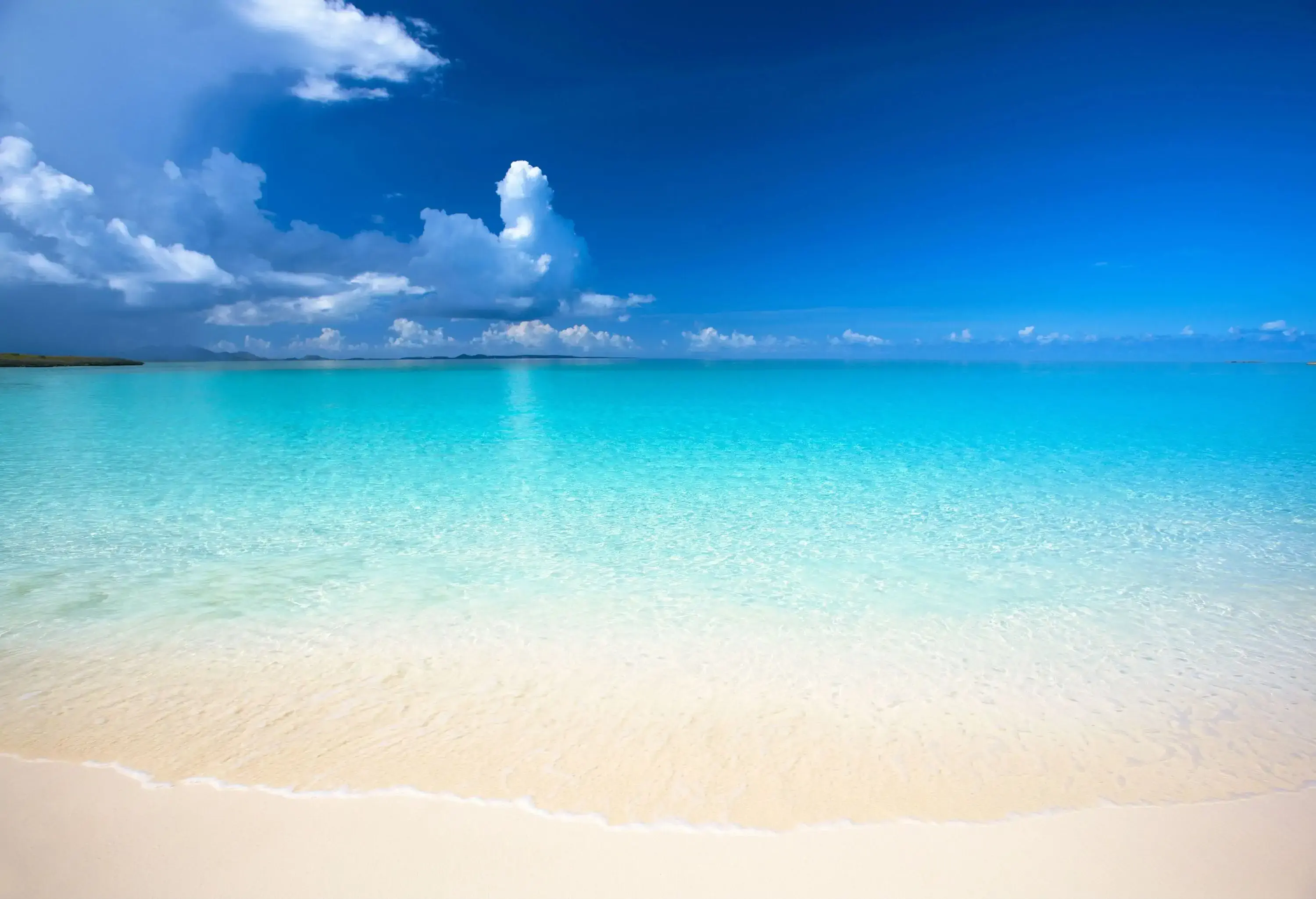 A pristine white beach with vast ocean views.