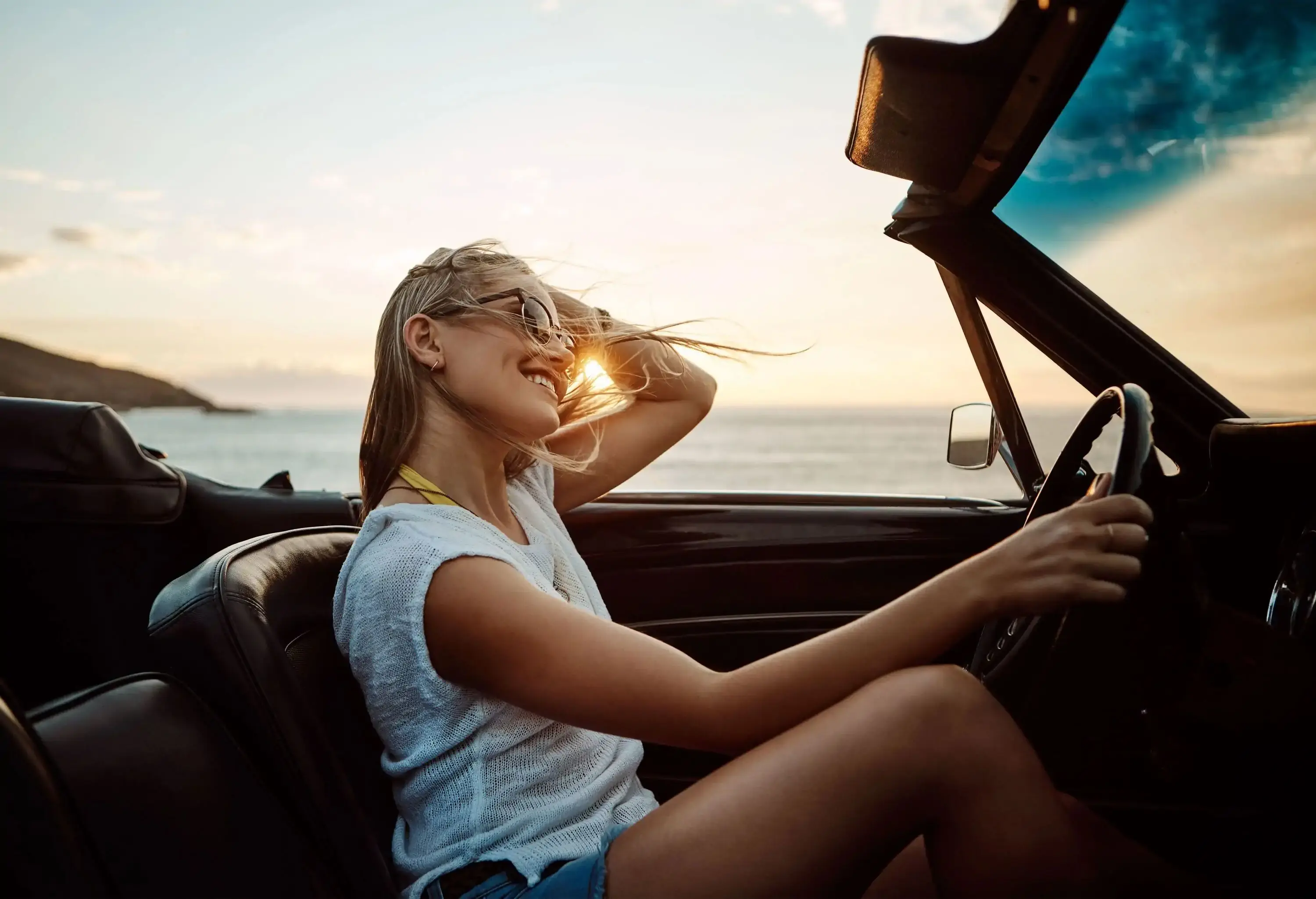 Shot of a happy young woman enjoying a summer’s road trip