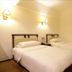 Chengdu Tianfu Lidu Hotel in Chengdu: twin beds in a simple guest room with wall lamps and wood floors