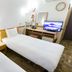Toyoko Inn Gumma Isesaki Ekimae guest room with two single beds, desk, TV and mirror in Isesaki
