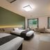 The Seiunso Resort Hotel & Spa in Unzen: twin beds, sitting area, and window views of greenery