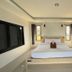 Mon Ing Dao in Mae Rim guest room with bed, desk, wall-mounted TV and windows