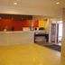 Hakuba Gondola Hotel lobby in Hakuba with front desk, red accent wall, and yellow tile floor
