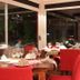 Rio Arriba Suites Apartments y Resto in Bella Vista dining area with red chairs and set tables by large windows