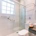 Pousada La Toscana bathroom in Campos do Jordão with walk-in shower, sink, and granite counter