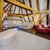 Hotel Svambersky dum attic suite in Český Krumlov with freestanding tub, sofa, and exposed beams