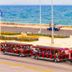 Aht Colonial Hostel in Havana with a red tourist tram by the seaside promenade