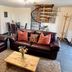 Dolgun Uchaf Guesthouse in Dolgellau: cozy lounge with leather sofas, dining table and spiral staircase