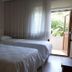 Nur Apart Marmaris room with two twin beds, sheer curtains, and open door to greenery
