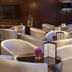 AC Hotels by Marriott A Coruna lounge with cream chairs, small tables, and wall-mounted TV in A Coruña