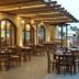 Outdoor terrace dining at Melpo Antia Hotel & Suites in Ayia Napa with wooden tables and arched windows