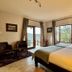 River Crossing Lodge in Windhoek guest room with twin beds, seating area, and mountain-view windows