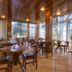Dining room at Pousada La Toscana in Campos do Jordão with large windows and forest views