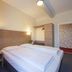 Hotel Cafe Lieb Bamberg guest room with double bed, bedside lamps and open wardrobe