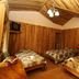 Historias Lodge in Monteverde guest room with three beds and wood-paneled walls