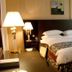 Sharjah Palace Hotel in Sharjah guest room with king bed, bedside lamps, desk and upholstered chair
