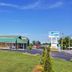 Scottish Inns Mcminnville exterior in McMinnville with green roof, roadside sign, and open lawn