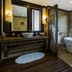 Melia Ba Vi Mountain Retreat bathroom with soaking tub, wooden vanity and forest view in Ba Vi