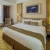 Grand Keisha Yogyakarta guest room with king bed, armchairs, desk and city view