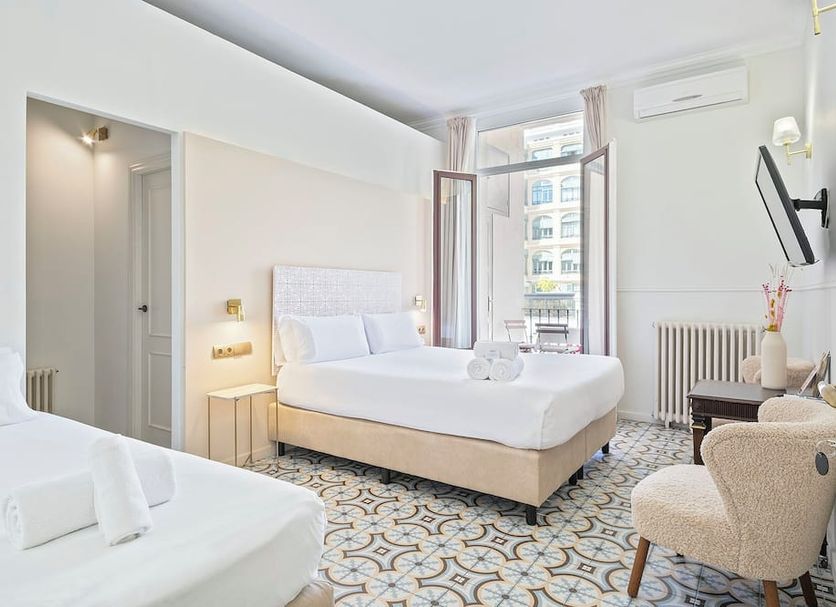 Mihlton Barcelona Boutique B&B guest room with twin beds, balcony door and city view in Barcelona