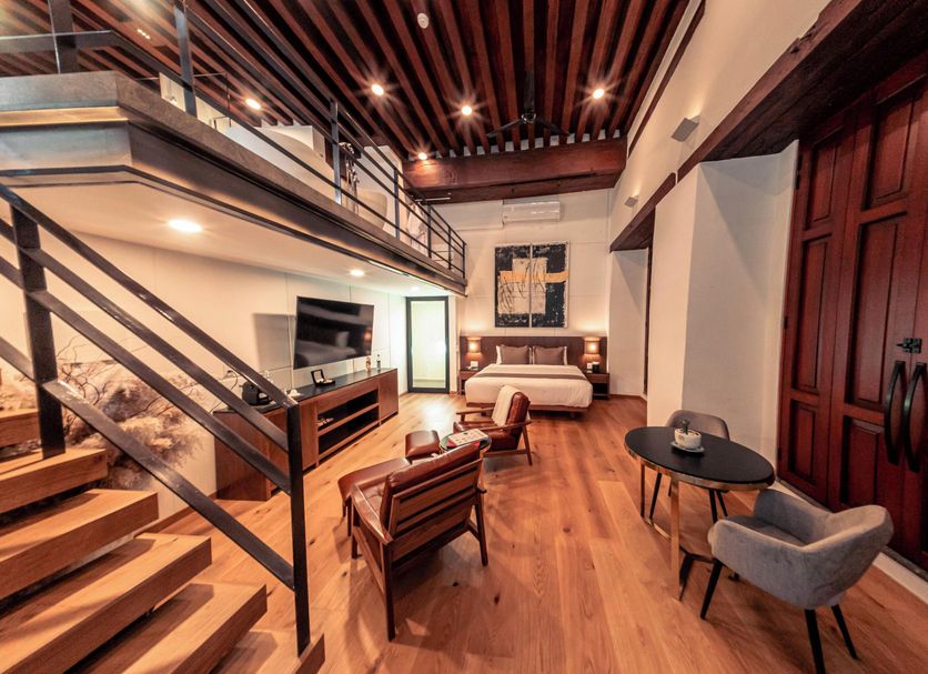 Domingo Santo Hotel Boutique in Mexico City loft-style suite with staircase, seating area and wood ceiling