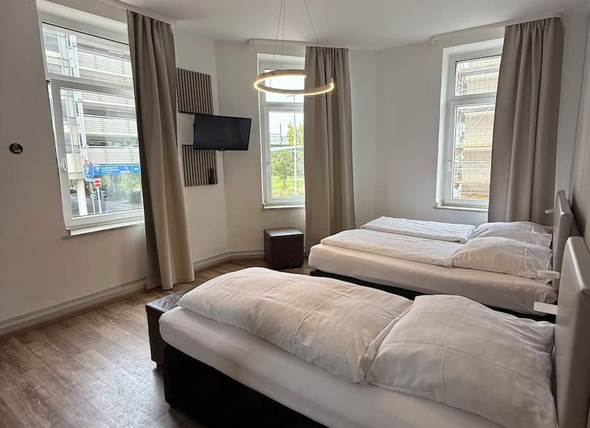 Central Hotel Duisburg room with two single beds, large windows, and curtains in Duisburg