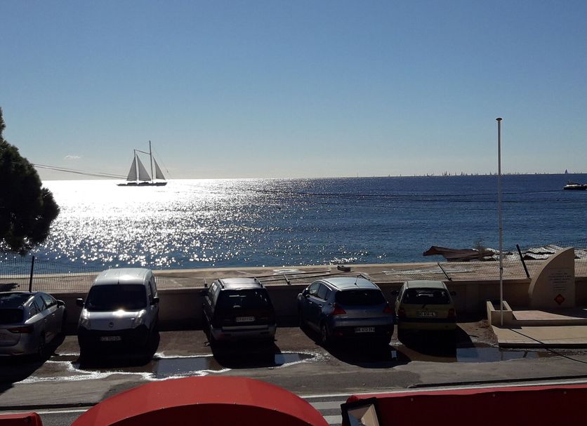Hôtel La Villa in Sainte-Maxime with sea view, parked cars, and a sailboat on the horizon