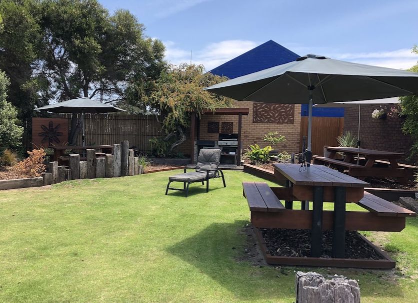 Mariner Motel in Portland with grassy courtyard, picnic tables, lounge chairs and shaded umbrellas