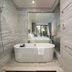 Anatole Hotel Hanoi bathroom with freestanding tub, walk-in shower and city view through glass wall