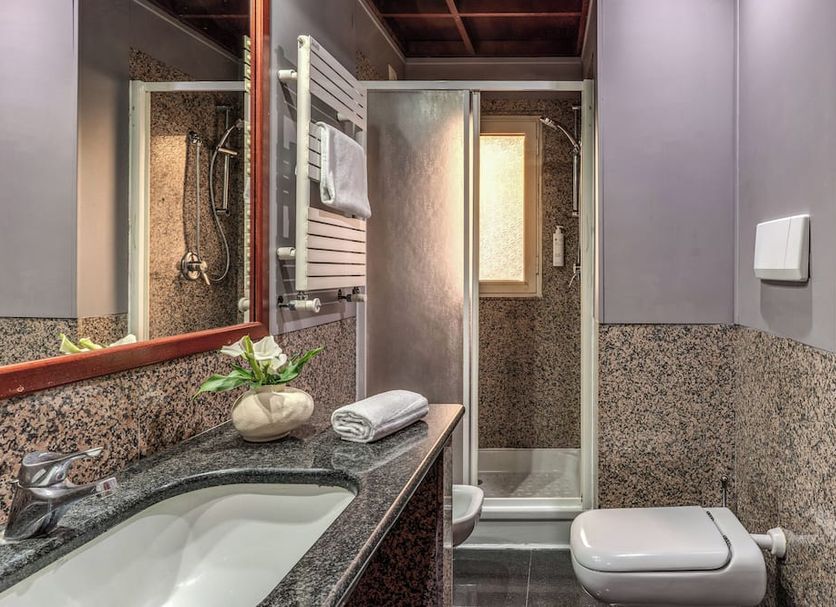 Hotel Madison Rome bathroom with granite vanity, shower stall, towel rack, and wall-mounted toilet