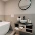 Witte Berken Natuurhotel Epe bathroom with freestanding tub, round mirror, and vessel sink