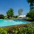 Hotel Villa Soligo pool terrace with lounge chairs and white cabanas in Farra di Soligo