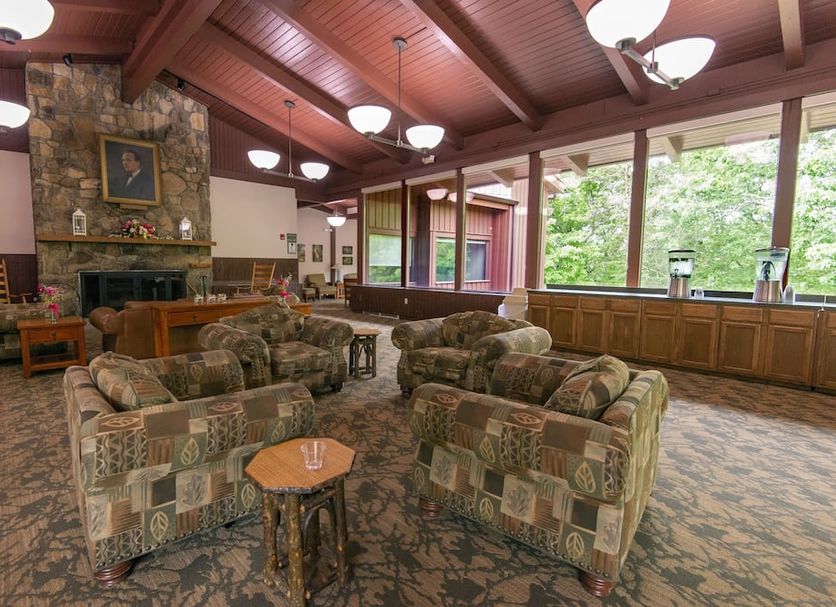 Carter Caves State Resort lounge in Olive Hill with patterned armchairs, stone fireplace and large windows