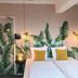 Hotel Credible Nijmegen room with twin beds, banana leaf wall mural, and hanging lights