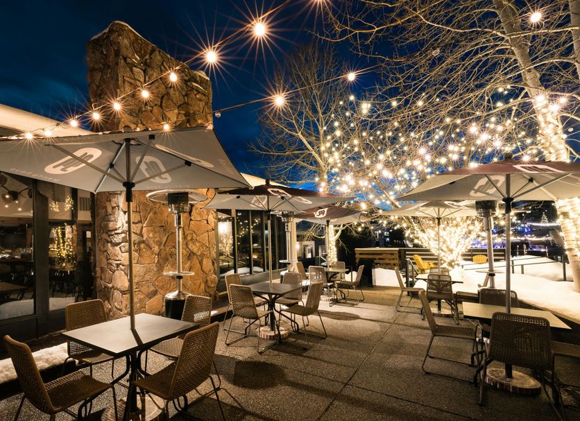 Gravity Haus Steamboat patio with string lights, outdoor tables and heaters in Steamboat Springs