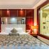 Shijiazhuang Shen Zhou 7 Star Hotel guest room with king bed, bedside lamps and a glass bathroom wall
