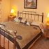Ard na Breatha in Donegal bedroom with wrought-iron bed, bedside lamps and wood floor