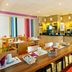 Residhome Bures La Guyonnerie breakfast area with tables, coffee station and red bench seating
