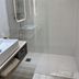 Hôtel Saint-Clair, côté Plage in La Grande-Motte bathroom with glass shower, vanity sink and folded towels