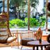 The Moana in Chatan lobby with hanging chair, round tables and large windows to tropical greenery