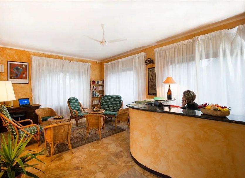 Elvezia Baveno hotel lobby with reception desk, wicker chairs, and large windows