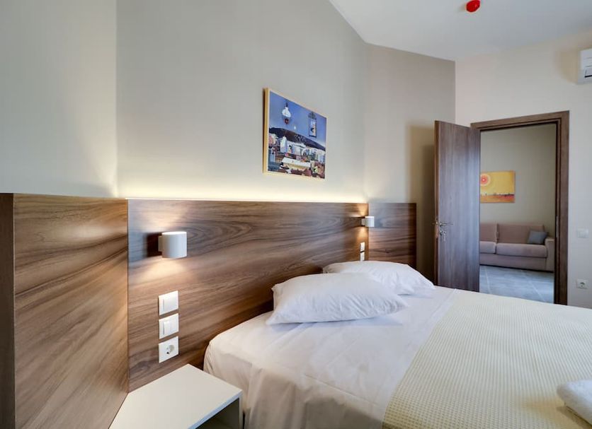 Athens Comfort Athens guest room with twin beds, wood headboard, and doorway to sitting area