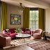 Zelda Dearest in Asheville lounge with pink seating, patterned ottomans, and large windows
