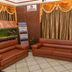 Hotel Maurya International lobby seating area in Chennai with brown sofas, gold drapes, and tiled floor