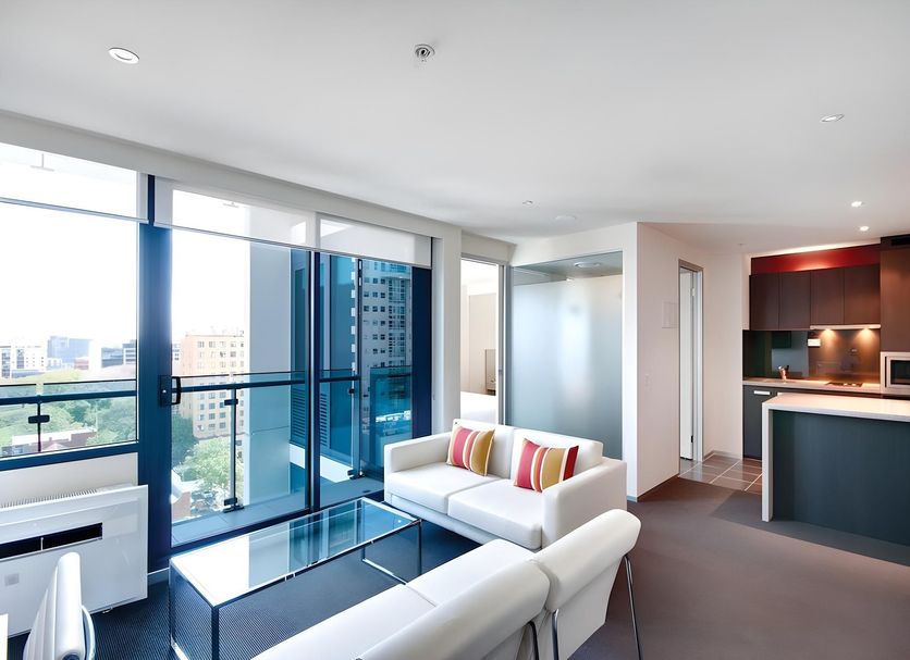 City Tempo Melbourne apartment with floor-to-ceiling windows, city views, sofa and kitchenette