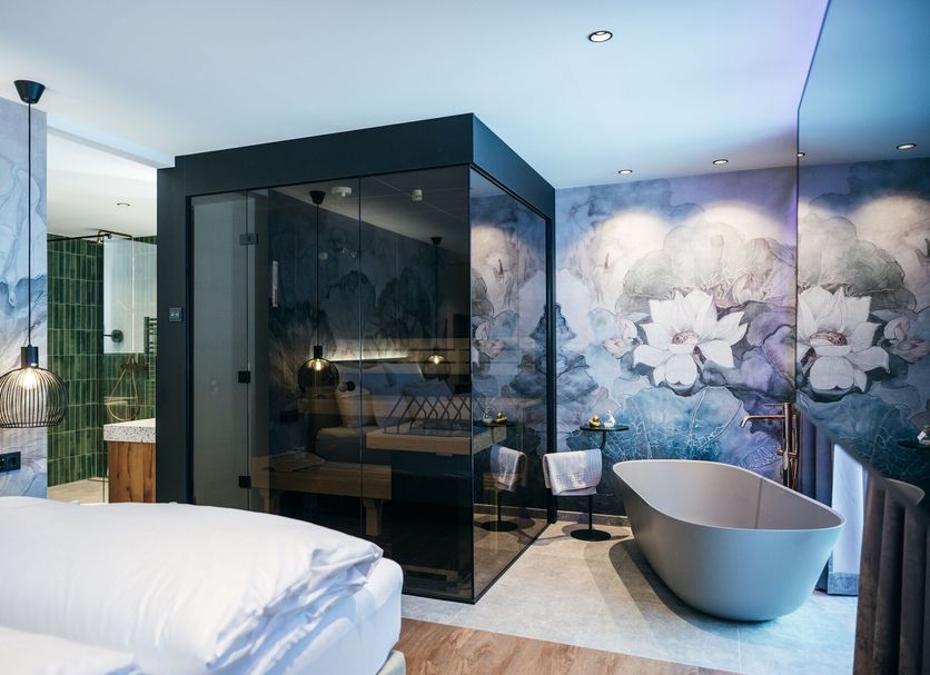 Berghotel Hochfügen in Fügen bathroom with freestanding tub and floral mural