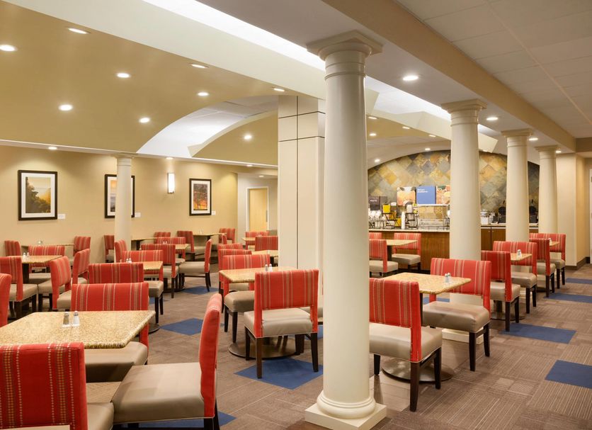 Comfort Inn & Suites Presidential Little Rock dining room with red striped chairs and white columns