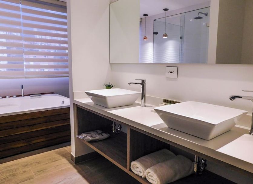 Hotel Lomas 10 Medellín bathroom with double vessel sinks, mirror, and wood vanity