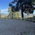 Villa Ambrosina in Impruneta with a gravel parking area and mountain views under a clear sky